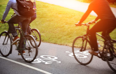 Cykelbana med cyklister i motljus