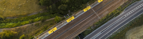 Tåg, järnväg och väg fotograferat ur flygperspektiv