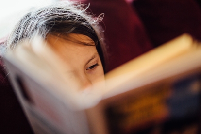 Ung person som koncentrerat läser en bok. Foto: Johnny McClung/Unsplash