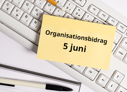 Gul post-it-lapp med texten "Organisationsbidrag 5 juni" på ett tangentbord med penna och anteckningsblock.