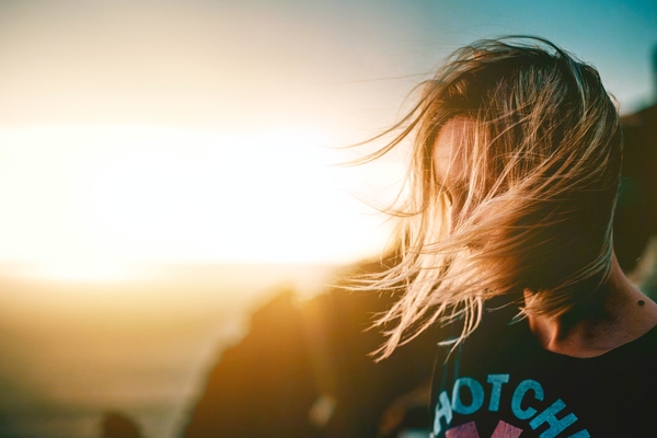 Person med vind i håret vid solnedgång. Foto: Jurica Koletic/Unsplash