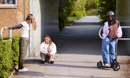 Tre unga personer ute, en står på sparkcykel och de andra två pratar vid en husvägg. Källa: Forskningsrådet Forte.