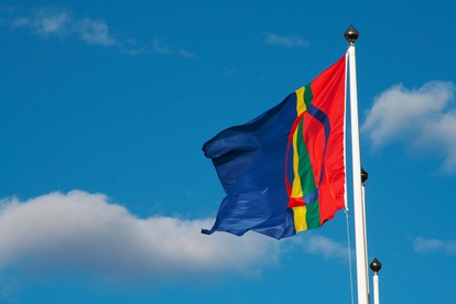 Samisk flagga vajar mot en klarblå himmel. Foto: Marie Enoksson 