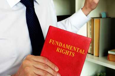 Person i kostym håller en bok med titeln "Fundamental Rights". Foto: Vitaliy Vodolazskyy/Mostphotos.com