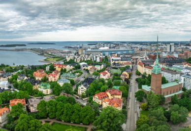 Flygfoto över stad vid vatten med en blandning av moderna och traditionella byggnader. Foto: Mostphotos.com/Hansenn.
