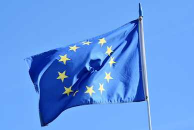 Europeiska unionens flagga vajar mot en klarblå himmel.
