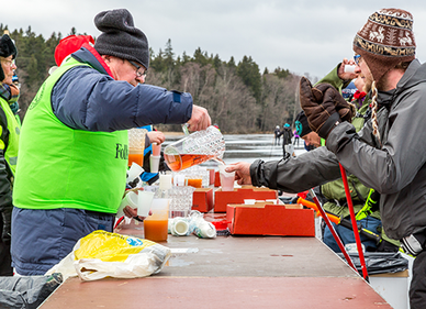Personer serverar varm dryck utomhus.
