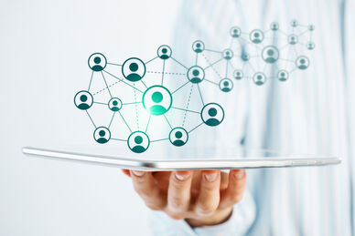 Person som håller en digital surfplatta med ett nätverk av anslutna punkter som svävar ovanför.