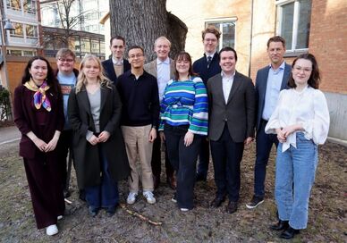 Medlemmar i MUCF:s ungdomsråd samt MUCF:s generaldirektör Magnus Jägerskog står utomhus framför ett stort träd och en tegelbyggnad. Foto: Matilda Andersson, MUCF