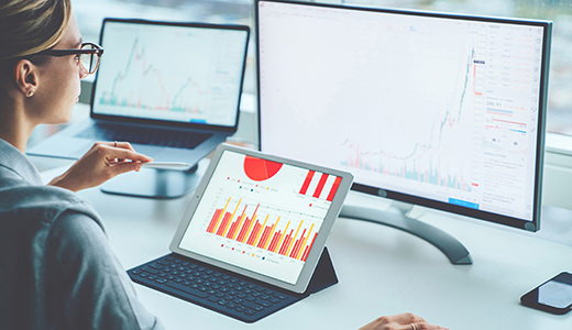 Person arbetar framför flera skärmar.
