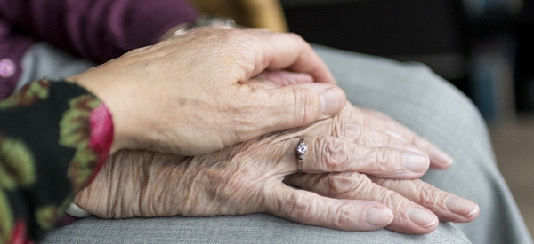 En äldre kvinnas händer hålls av en yngres. Foto: Pixabay