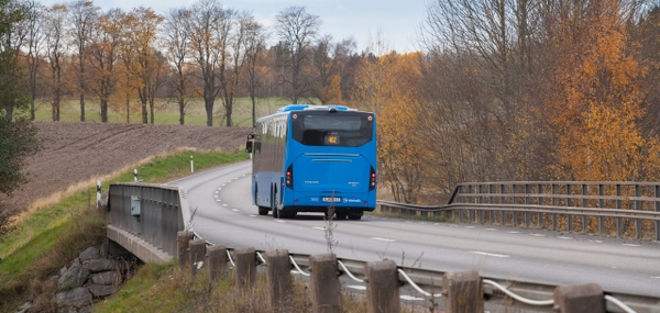 Buss på väg i höstlandskap