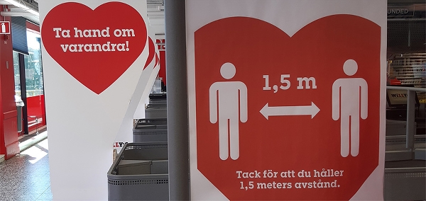 Butikslokal med informationsskyltar med röda hjärtan och texten Ta hand om varandra!