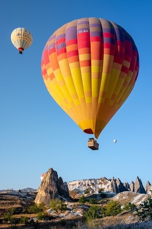 Bild på varmluftsballong ovanför höga klippor