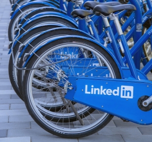 Likadana blå cyklar står uppradade bredvid varandra. Det står "LinkedIn" på ramen.