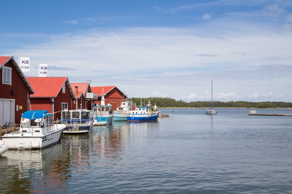 Sommarmiljö med båtar och sjöbodar vid Spikens fiskeläger på Kållandsö vid Vänern.