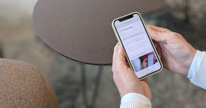 Närbild på en person som håller i en mobiltelefon.