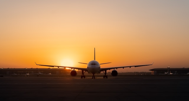 Flygplan på landningsbanan vid solnedgång.