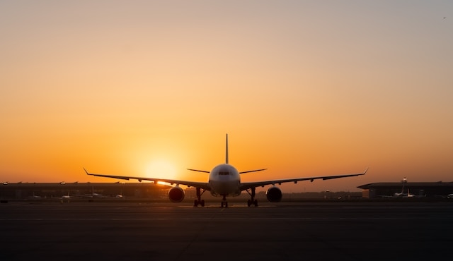 Flygplan på landningsbanan vid solnedgång.