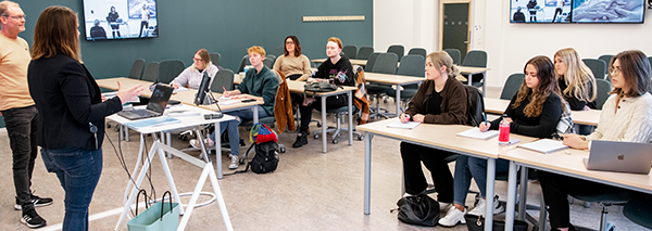 Lärare som presenterar i ett klassrum för studenter vid bord