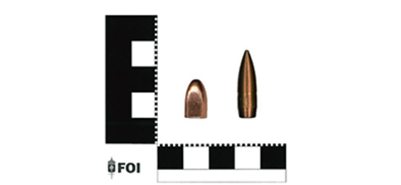 Två kulor av olika sorters ammunition.
