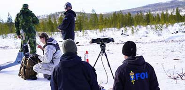Militärer och forskare på ett fält.