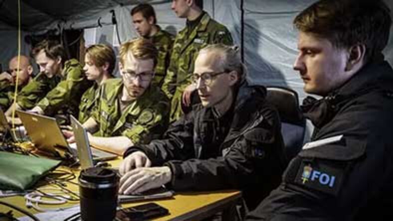 Militärer och forskare vid bord.