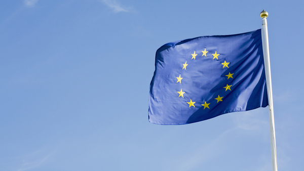 Europeiska unionens flagga vajar mot en klarblå himmel.