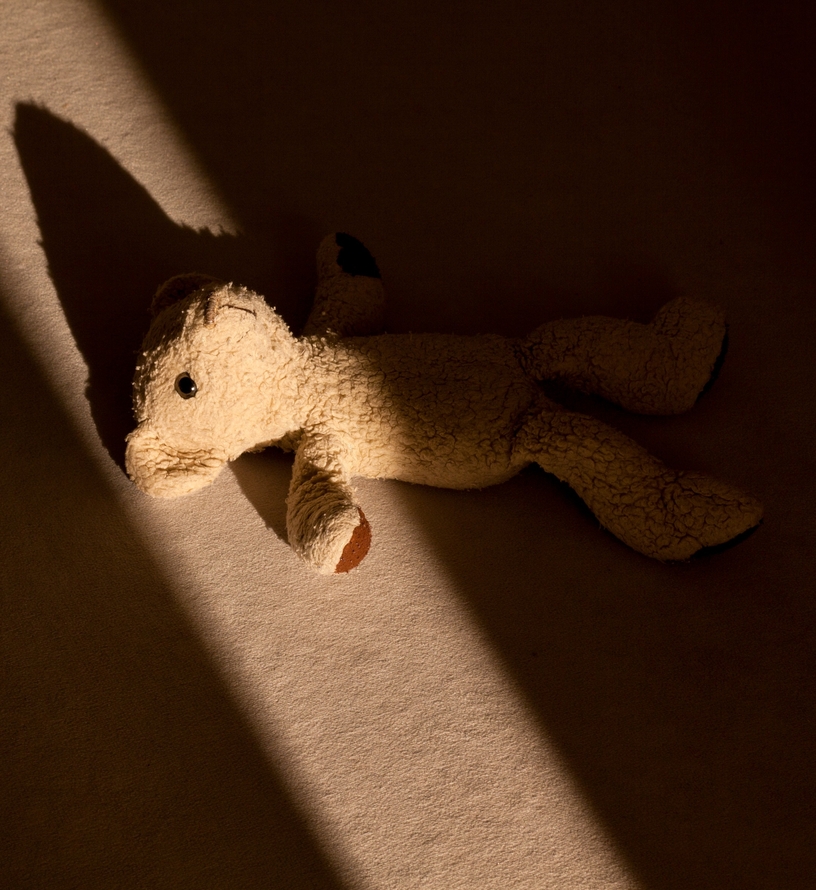 En nalle ligger slängd på golvet.