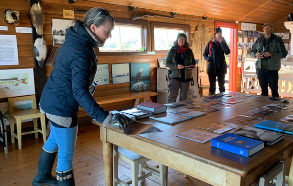 Naturguide Ann-Sofi Andersson guidar en grupp besökare inne i Jaktstugans museum. Foto: Länsstyrelsen.