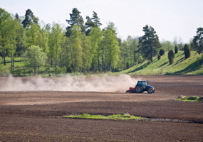 Traktor utför vårbruk på åker