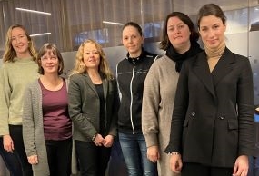 Styrgruppens medlemmar står uppradade i kontorsmiljö. 