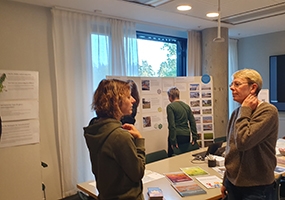 Människor pratar och tittar på utställningsskärmar. Foto: Länsstyrelsen.