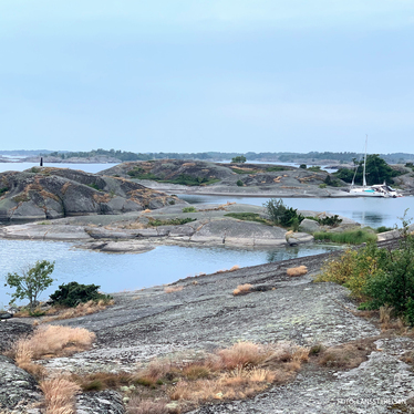 Vy från Låg-Hallskär. Öar, vatten emellan och några förtöjda segelbåtar.