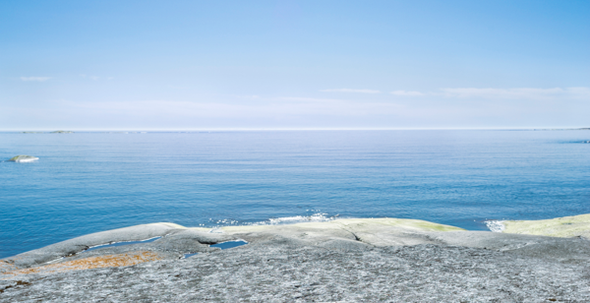 Kala klippor vid havet, utsikt mot horisont.