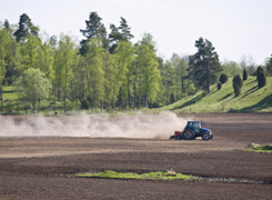 Bilden visar en traktor som harvar.