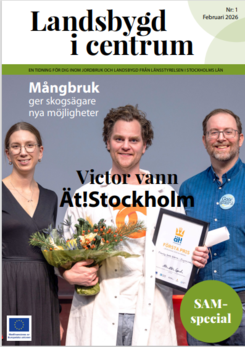 Omslag med tre leende personer på scen; personen i mitten håller en blombukett och ett diplom.