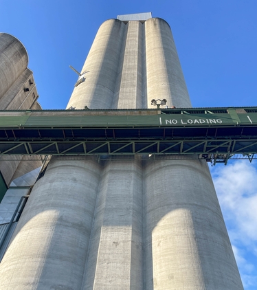 Betongsilo i perspektiv från marken mot klarblå himmel