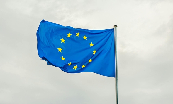 Europeiska unionens flagga som vajar i vinden mot en molnig himmel