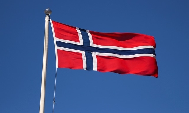 Norska flaggan mot blå himmel. Foto: Pixabay. 