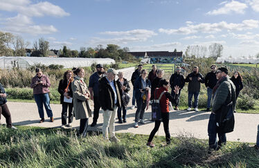En grupp människor på en gångväg genom ett grönt landskap.
