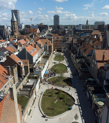 Organiskt formade grönområden på rad mellan husen i en stad.