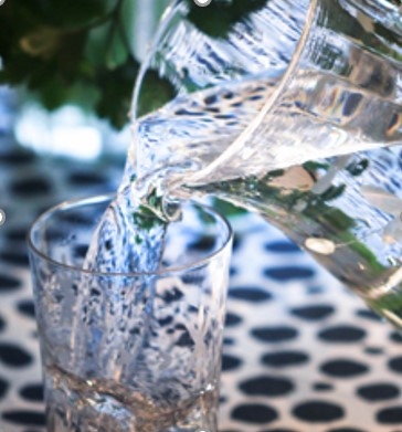 Vatten hälls upp i ett glas från en glaskaraff