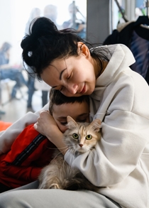 Kvinna från Ukraina kramar ett barn och en katt.