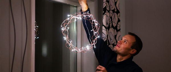 Man hänger upp julbelysning i ett fönster