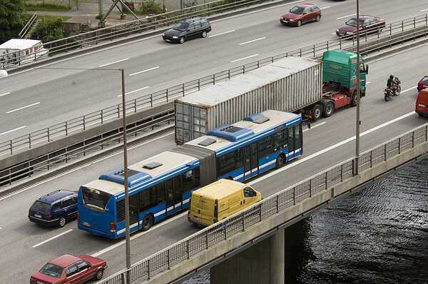 Bilar, bussar och lastbilar på en bro över vatten.