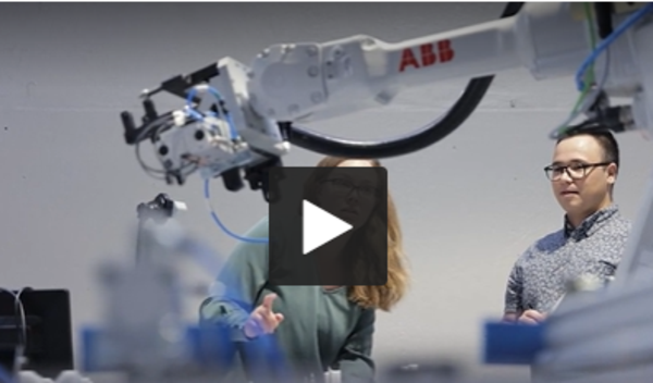 Kvinna och man vid robot