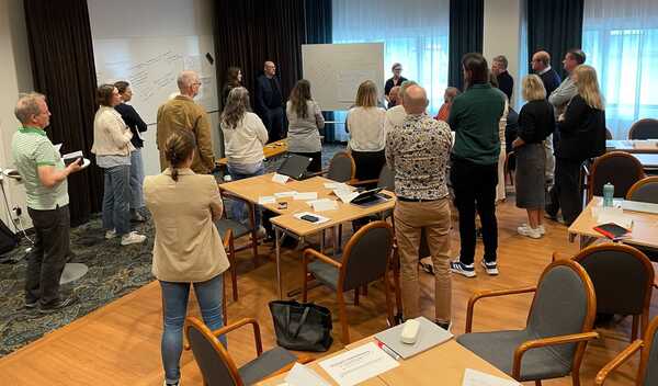 Grupp står och tittar på en whiteboard