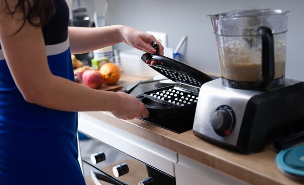 Köksbänk med våffeljärn, hushållsassistent och överdelen av en spis