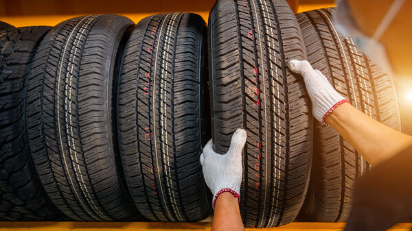 En bild på händer som tar ett däck ur ett ställ med många däck